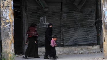 Syrian women walk with their children in the northern Syrian city of Aleppo on March 23, 2013. In Aleppo, nine months into fighting that has devastated many districts, life has slowly started to return to what passes for normal in Syria today. AFP 