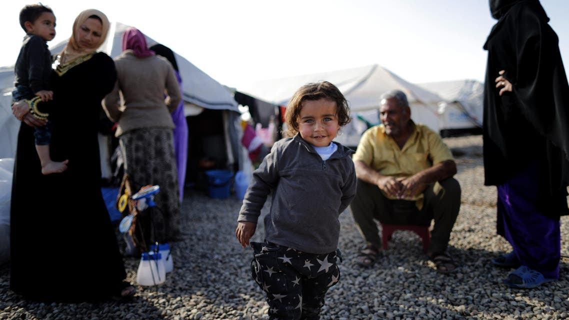 This file photo taken on December 3, 2016 shows a displaced Iraqi boy, who fled the violence in the Iraqi northern city of Mosul as a result of a planned operation to retake the city from jihadists, posing at Hasan Sham refugee camp, some 30 kilometres east of Mosul.