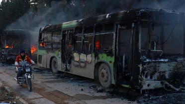 A man on a motorcycle drives past burning buses while en route to evacuate ill and injured people from the besieged Syrian villages of al-Foua and Kefraya, after they were attacked and burned, in Idlib province, Syria December 18, 2016. (Reutetrs)