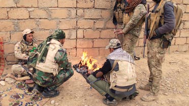 Members of the Lions of the Tigris, a group of Sunni Arab fighters and part of the Hashid Shaabi (Popular Mobilization Comimittee) warm themselves near a fire during a pasue in a military operation against ISIS militants in Shayyalah al-Imam, Iraq November 30, 2016. (Reuters)