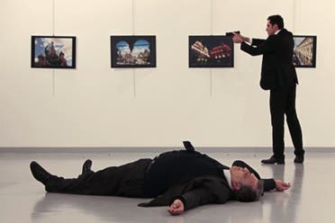 This picture taken on December 19, 2016 shows Andrey Karlov (bottom), the Russian ambassador to Ankara, lying on the floor after being shot by a gunman (R) during an attack during a public event in Ankara. (AFP)