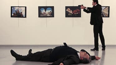 This picture taken on December 19, 2016 shows Andrey Karlov (bottom), the Russian ambassador to Ankara, lying on the floor after being shot by a gunman (R) during an attack during a public event in Ankara. (AFP)