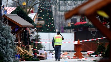 A policeman walks at the Christmas market near the Kaiser-Wilhelm-Gedaechtniskirche (Kaiser Wilhelm Memorial Church), the day after a terror attack, in central Berlin, on December 20, 2016. German police said they were treating as "a probable terrorist attack" the killing of 12 people when the speeding lorry cut a bloody swath through the packed Berlin Christmas market. Tobias SCHWARZ / AFP