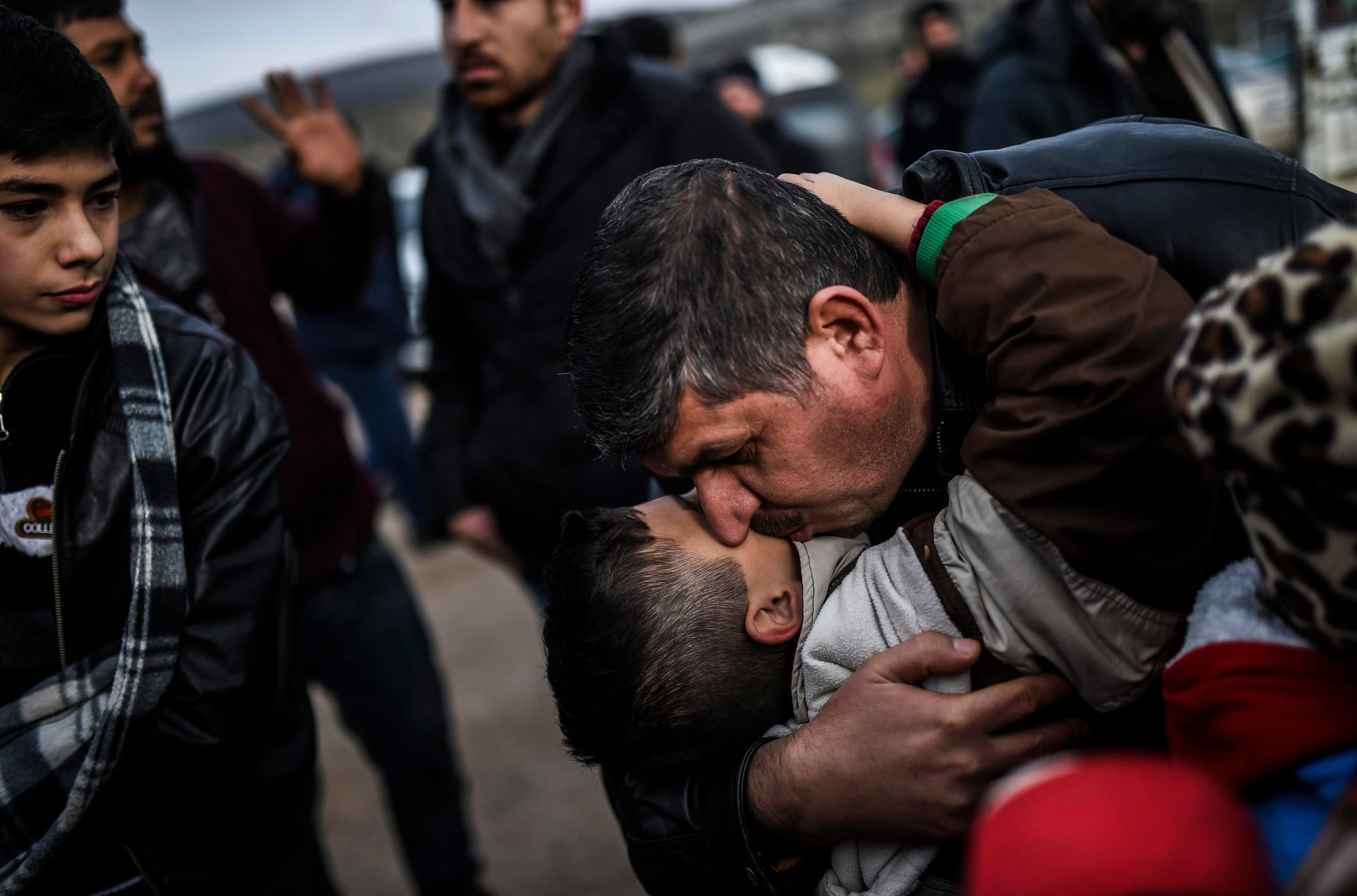 Syrian father Ali embraces one of his children, Zeyn, upon their arrival from the Syrian city of Idlib to the Turkish crossing gate of Cilvegozu in Reyhanli in Hatay near the Syrian border on December 17, 2016. (AFP)