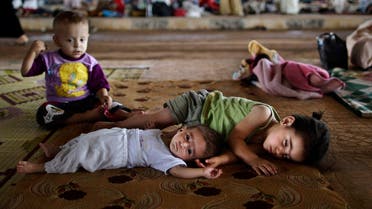 Syrian children, who fled their home with their family due to fighting between the Syrian army and the rebels, lie on the ground, while they and others take refuge at the Bab Al-Salameh border crossing, in hopes of entering one of the refugee camps in Turkey, near the Syrian town of Azaz, Sunday, Aug. 26, 2012.