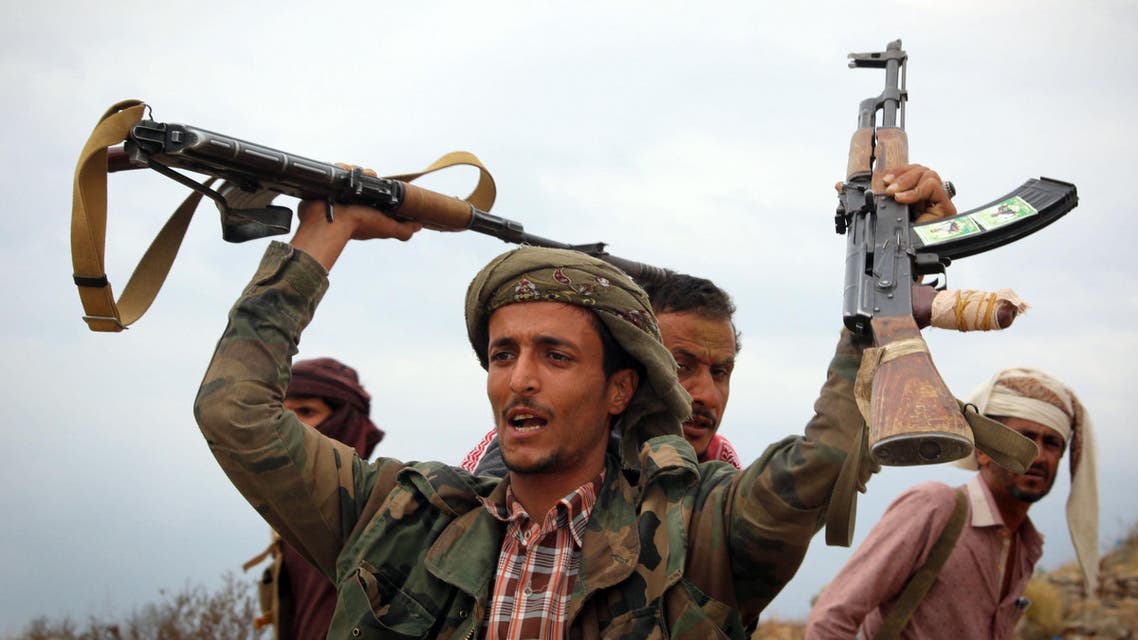 A Yemeni tribesman from the Popular Resistance Committee, supporting forces loyal to Yemen's Saudi-backed President Abedrabbo Mansour Hadi, raises weapons during clashes with Shiite-Huthi rebels in the country's third-city of Taez on December 19, 2016. Ahmad AL-BASHA / AFP