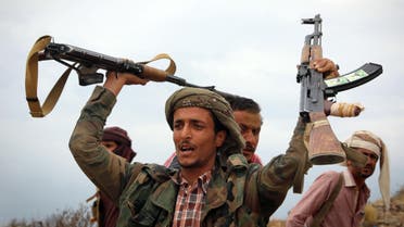 A Yemeni tribesman from the Popular Resistance Committee, supporting forces loyal to Yemen's Saudi-backed President Abedrabbo Mansour Hadi, raises weapons during clashes with Shiite-Huthi rebels in the country's third-city of Taez on December 19, 2016.  Ahmad AL-BASHA / AFP
