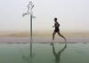 A man jogs in the fog at the Umm Suqeim beach in Dubai, United Arab Emirates, Wednesday, Dec. 28, 2016. A heavy seasonal fog engulfed the skyscraper-lined skyline of Dubai for several hours, causing some flights to be delayed at the world's busiest international airport. (AP Photo/Kamran Jebreili)