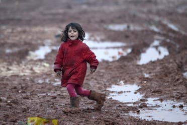 An internally displaced Syrian girl runs through mud in the Bab Al-Salam refugee camp, near the Syrian-Turkish border, northern Aleppo province, Syria December 26, 2016. REUTERS/Khalil Ashawi