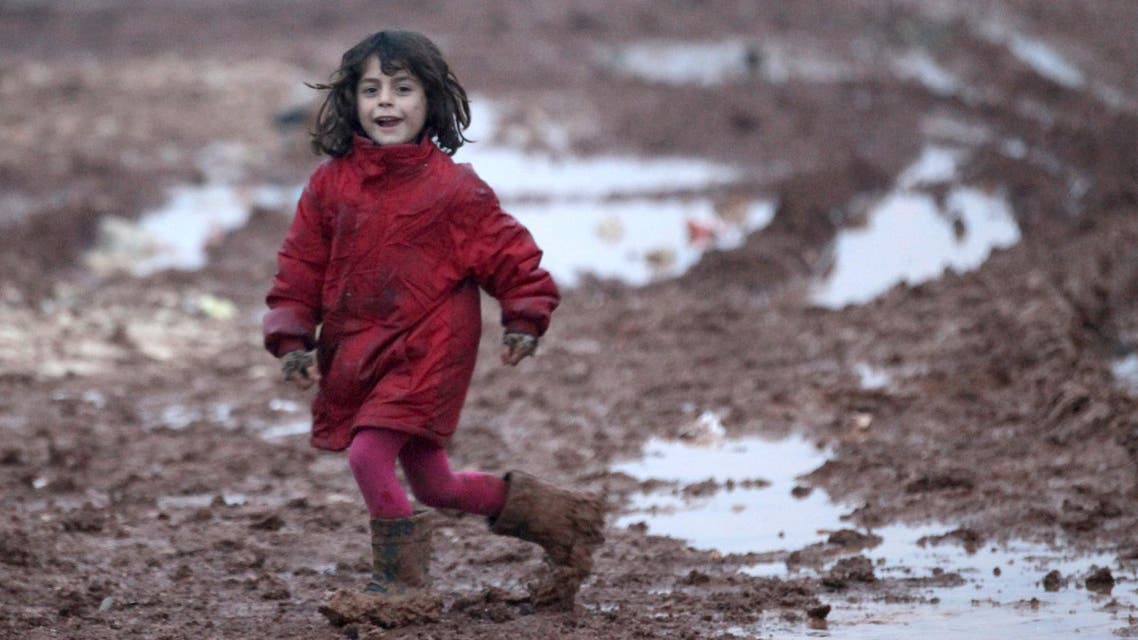 An internally displaced Syrian girl runs through mud in the Bab Al-Salam refugee camp, near the Syrian-Turkish border, northern Aleppo province, Syria December 26, 2016. REUTERS/Khalil Ashawi