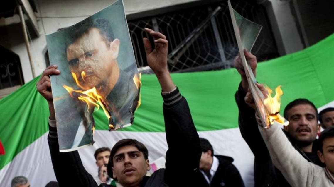 Protestors burn portraits of Syrian President Bashar Assad during an anti-government demonstration (photo credit: AP/Rodrigo Abd)