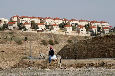 A Palestinian man rides a donkey near the Israeli settlement of Maale Edumim, in the occupied West Bank, December 28, 2016. (Reuters)