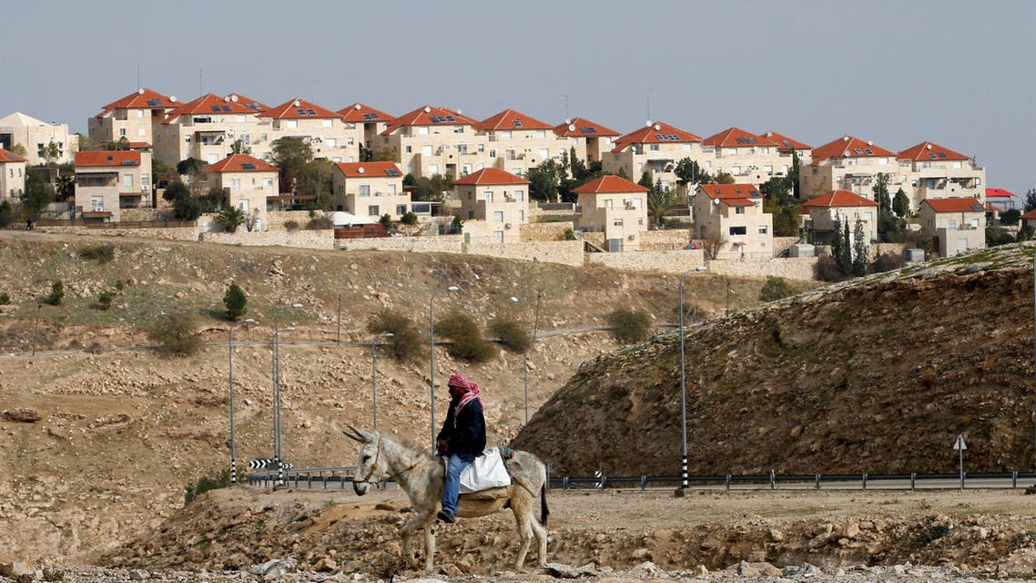 A Palestinian man rides a donkey near the Israeli settlement of Maale Edumim, in the occupied West Bank, December 28, 2016. (Reuters)