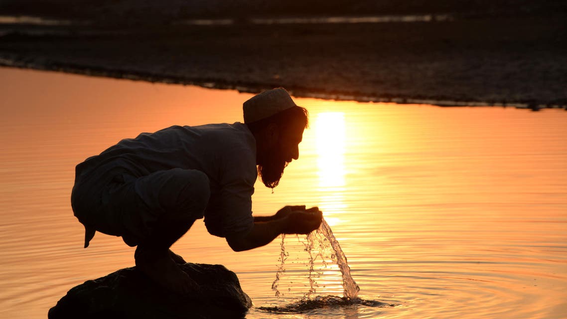 In this photograph taken on December 27, 2016, an Afghan man performs ablution before prayers in a river on the outskirts of Jalalabad. (AFP)