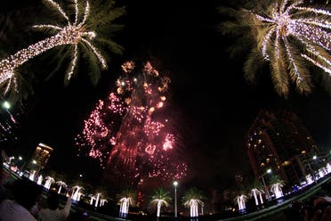 الألعاب النارية تضيء برج خليفة بينما يحترق برج خلفه في دبي ، الإمارات العربية المتحدة ، الجمعة 1 يناير 2016 (AP)