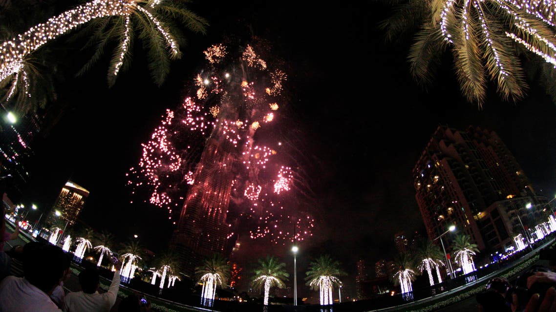 Fireworks illuminate the Burj Khalifa as a tower burns behind it in Dubai, United Arab Emirates on Friday, Jan. 1, 2016. (AP)