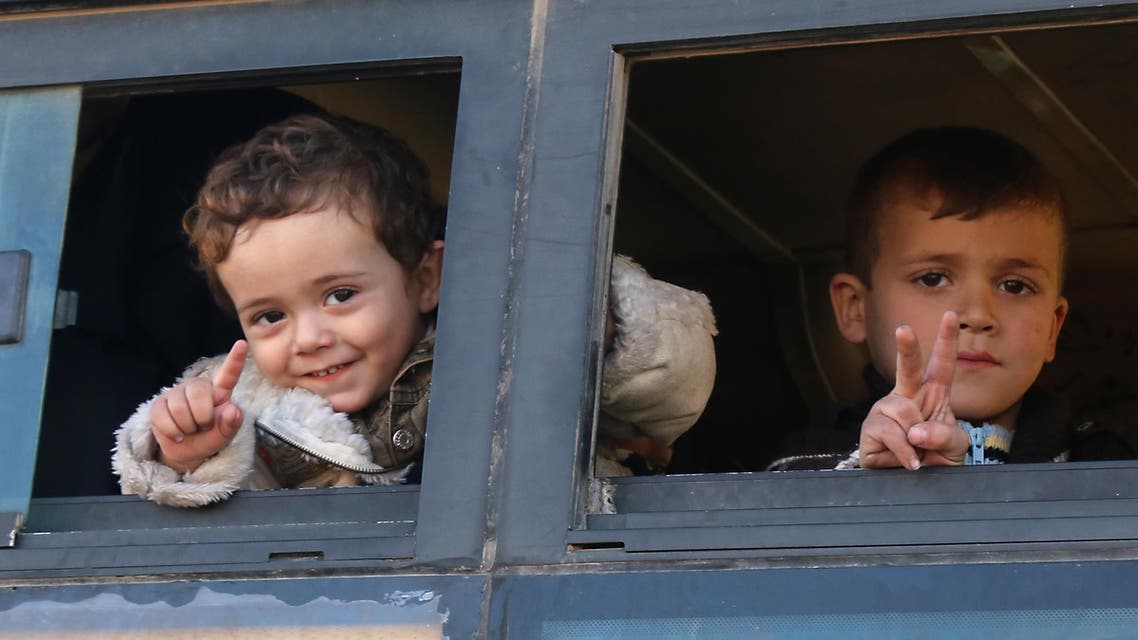 Syrian children, who were evacuated from rebel-held neighborhoods in the embattled city of Aleppo, gesture as they arrive in the opposition-controlled Khan al-Aassal region, west of the city, on December 15, 2016, (AFP)