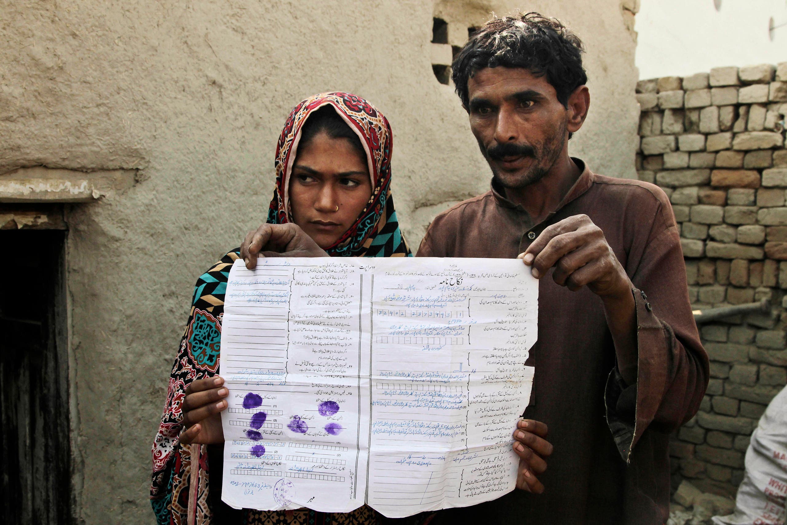 Mohammad Ramzan shows his marriage contract with his young bride Saima in Jampur, Pakistan. (AP)