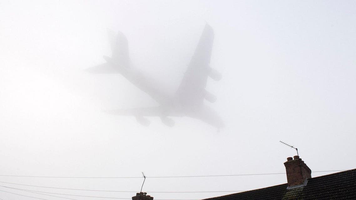 A Etihad Airways Airbus A380 comes in through the fog over housing to land at Heathrow Airport in west London. (AFP)