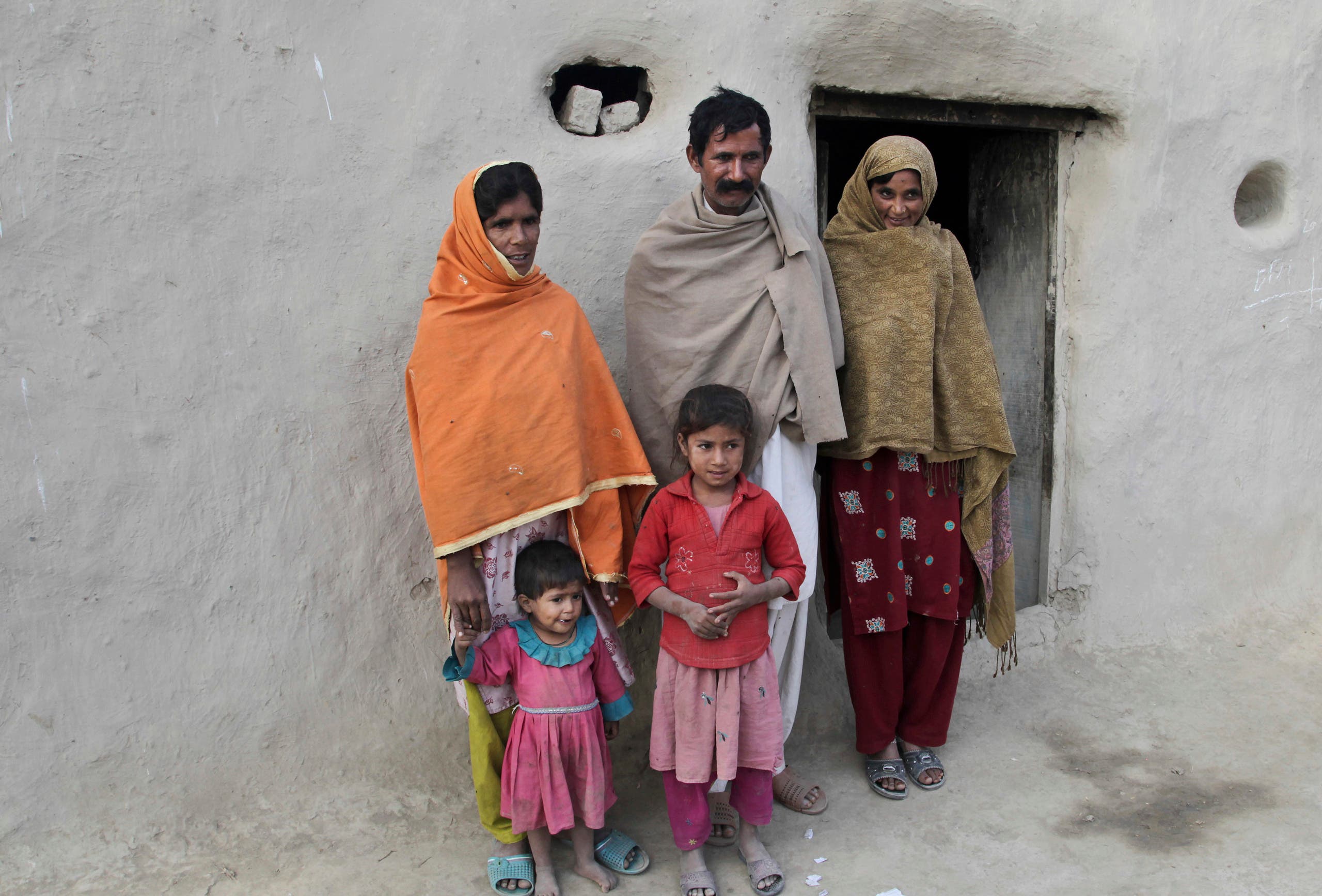 Wazir Ahmed, father of Saima who married Mohammad Ramzan, stands with his wives Sabeel right, and Jannat in Jampur, Pakistan. (AP)