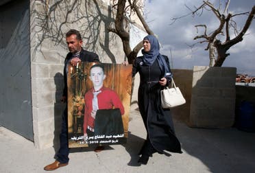 Rajaa and Yousri the mother and father of Abdul Fatah al-Sharif (portrait) head out into the streets in the West Bank town of Hebron on January 4, 2017, after watching on television the verdict of the trial of Israeli soldier Elor Azaria who killed their son. AFP