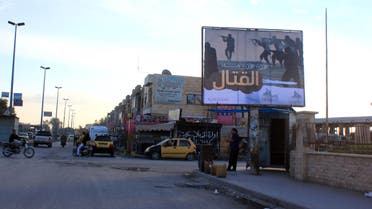 People walk under a billboard erected by the Islamic State (IS) group as part of a campaign in the IS controlled Syrian city of Raqqa on November 2, 2014