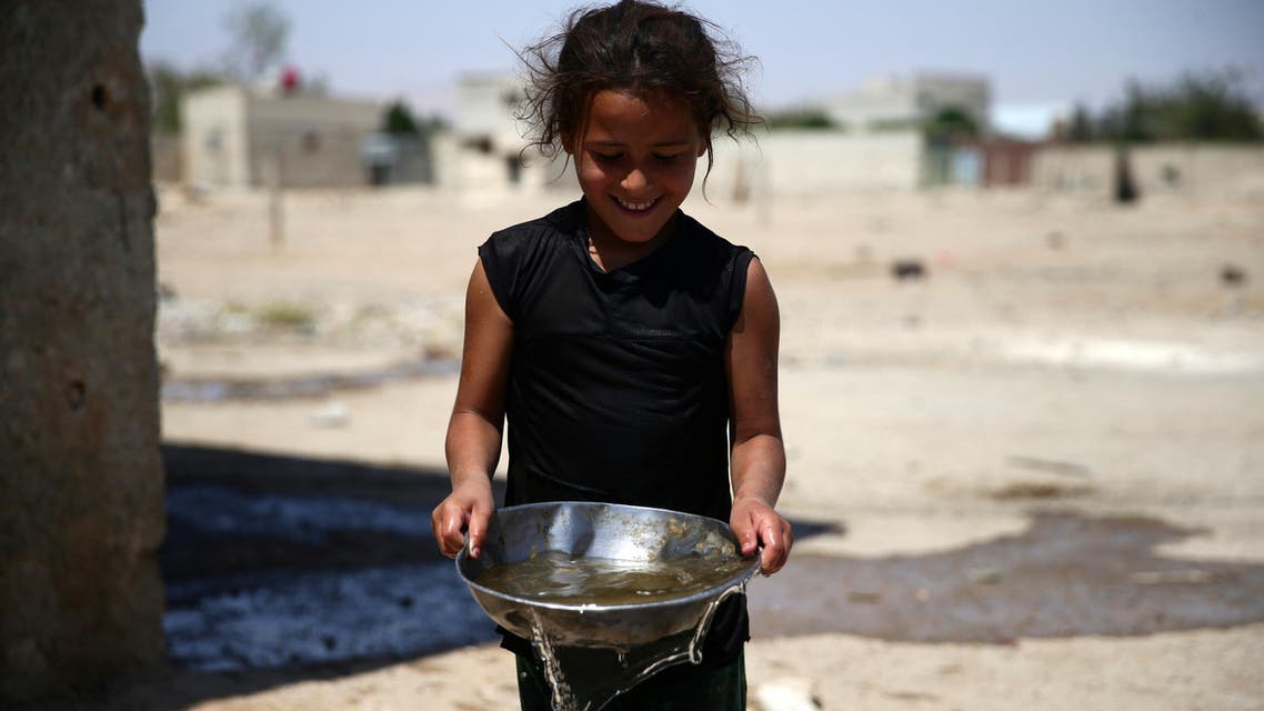 A girl carries a bowl filled with water, in the rebel held besieged town of Douma, eastern Damascus suburb of Ghouta, Syria, June 23, 2016. (Reuters)