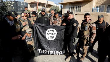Lieutenant General Abdelwahab al-Saadi (C) and members of Iraqi Counter Terrorism Forces hold an Islamic State flag which they pulled down during a battle with Islamic State militants, east of Mosul, Iraq, January 11, 2017. REUTERS/Ahmed Saad