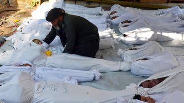 A man holds the body of a dead child among bodies of people activists say were killed by nerve gas in Ghouta, a rebel-controlled suburb of the Syrian capital Damascus, Syria August 21, 2013. REUTERS