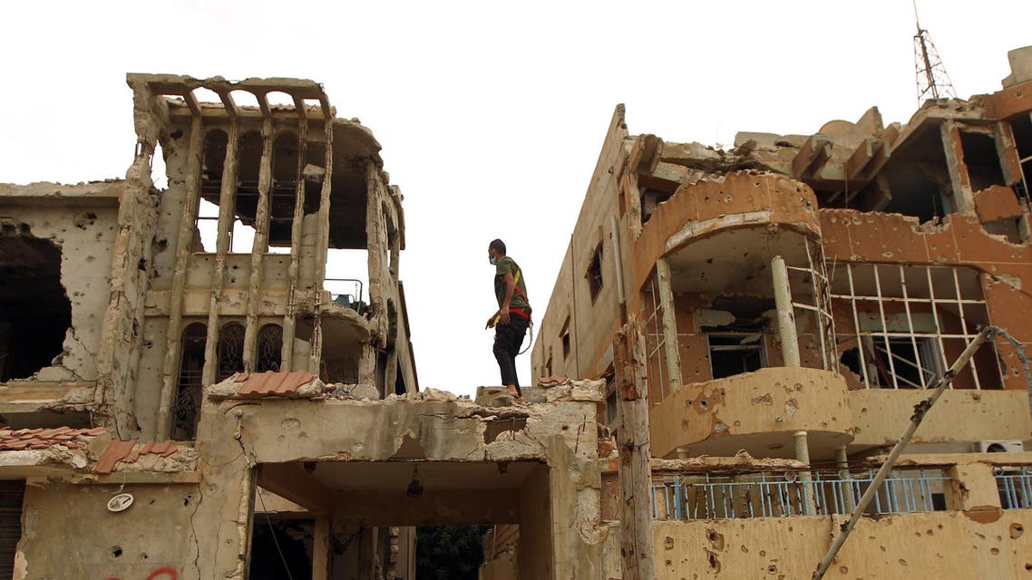 A Libyan man stands atop a destroyed building on February 29, 2016 as he works to get it reconnected to electricity in a central area that was recently reseized by Libya's internationally recognised government in the eastern coastal city of Benghazi. AFP