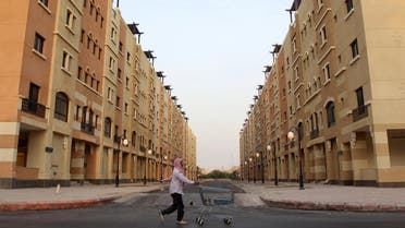 A man pushes a cart as he walks past residential buildings in Riyadh, Saudi Arabia. (Reuters)