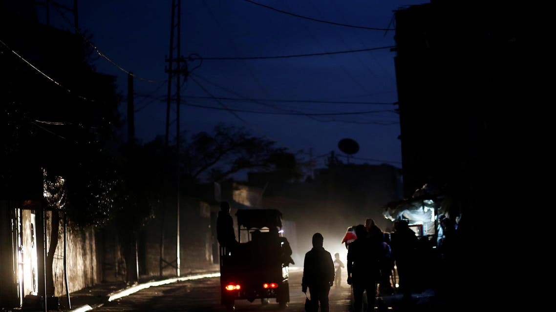 Palestinians walk on a street during a power cut in Beit Lahiya in the northern Gaza Strip. REUTERS