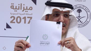 Saudi Finance Minister Mohammed Al-Jadaan shows documents during a press conference to unveil the country's national budget for 2017 on December 22, 2016 in Riyadh. (AFP)