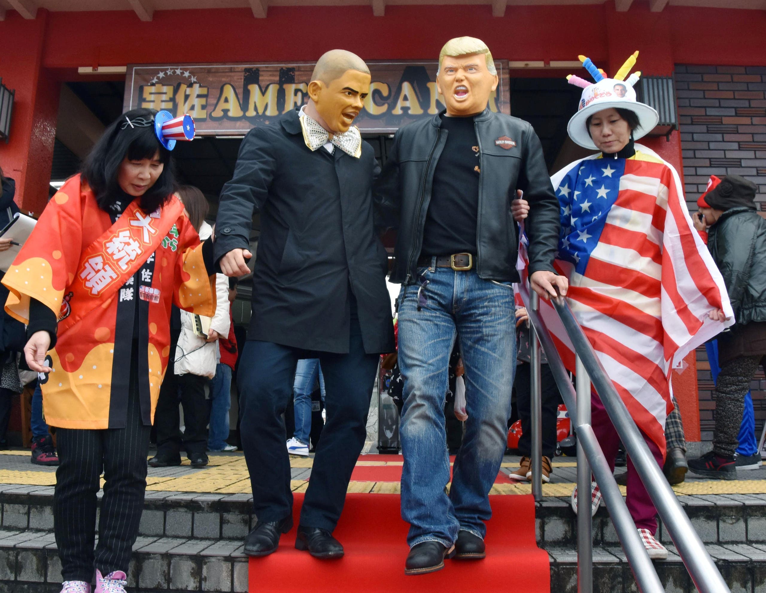 People wearing Barack Obama and Donald Trump masks walk down the stairs at JR Usa Station in the city of Usa in Oita Prefecture, southwestern Japan, in this photo taken by Kyodo on January 21, 2017. (Reuters)