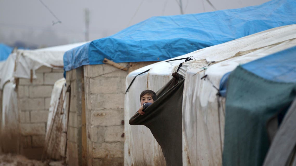 An internally displaced Syrian boy looks out his tent in the Bab Al-Salam refugee camp, near the Syrian-Turkish border, northern Aleppo province, Syria December 26, 2016. REUTERS/Khalil Ashawi