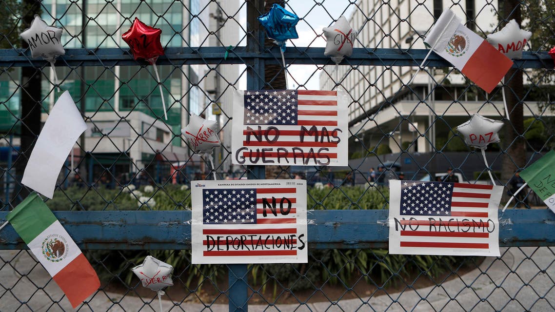 Signs that read in Spanish No more wars, No more deportations and No racism. hang from a fence in front of the U.S Embassy, during a march called by a local women's movement against U.S. President Donald Trump in Mexico City, Friday, Jan. 20, 2017. (AP)