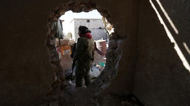 A rebel fighter stands near a hole in the wall as he carries his weapon on the outskirts of Al-Bab town in Syria January 22, 2017. REUTERS