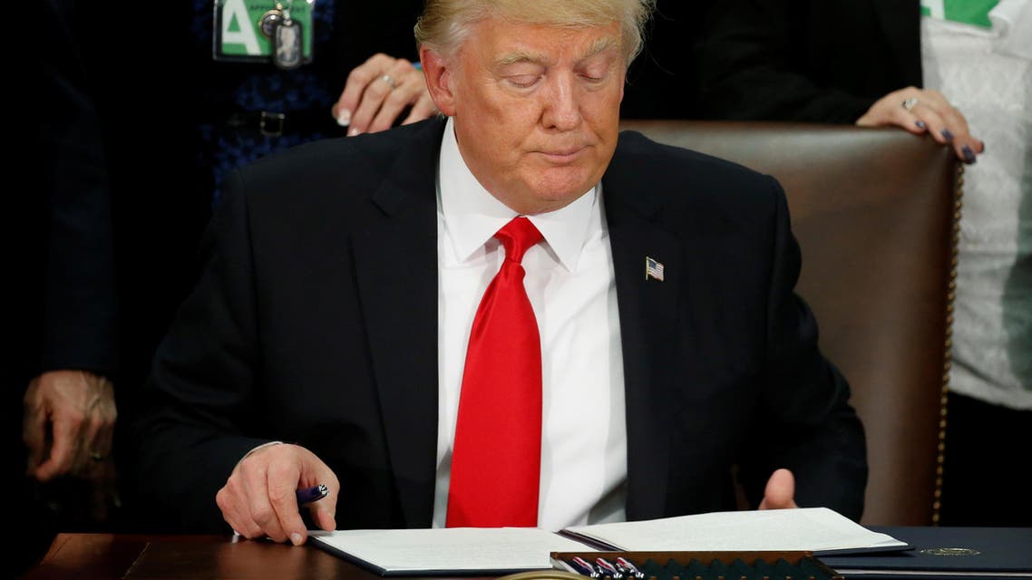 U.S. President Donald Trump reads an executive order before signing it at Homeland Security headquarters in Washington, U.S., January 25, 2017. reuters