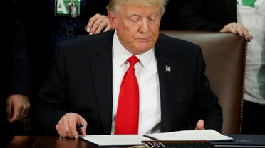 U.S. President Donald Trump reads an executive order before signing it at Homeland Security headquarters in Washington, U.S., January 25, 2017. reuters