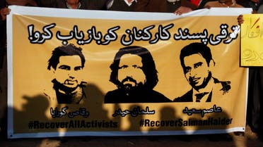 members of civil society hold a banner with pictures of missing rights activists, Waqas Goraya, Salman Haider, and Asim Saeed, during a demonstration. (AP)
