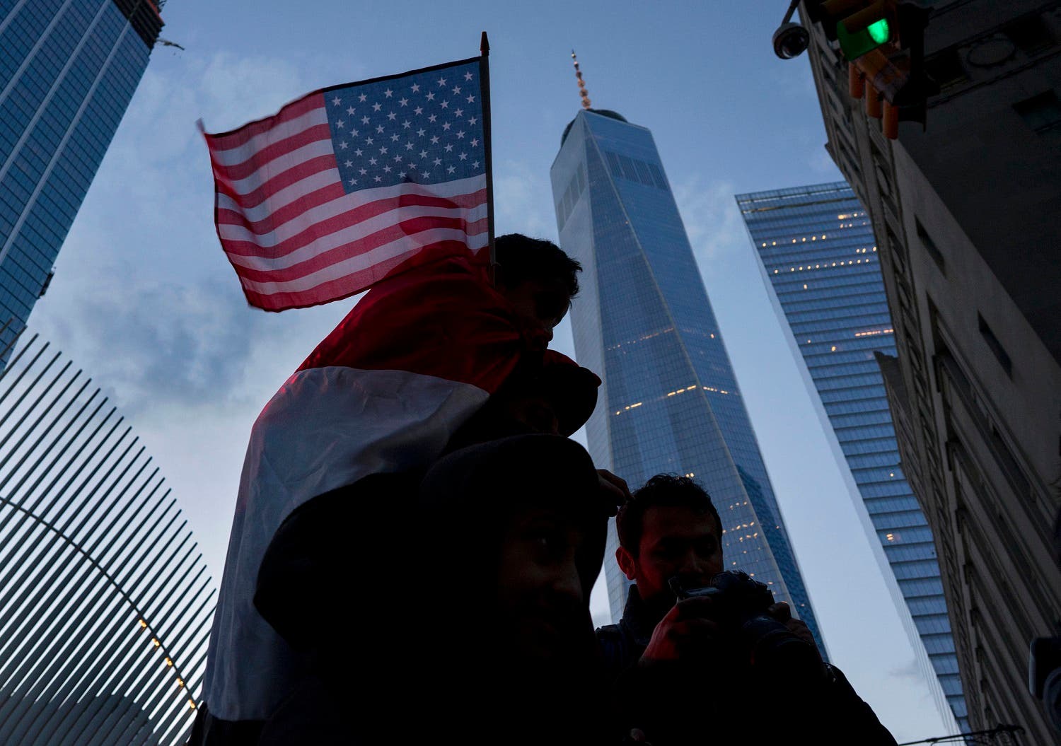 With One World Trade Center in the background, people march in New York, Sunday, Jan. 29, 2017, as they protest against President Donald Trump's executive order banning travel to the US by citizens of several countries. (AP Photo/Craig Ruttle)