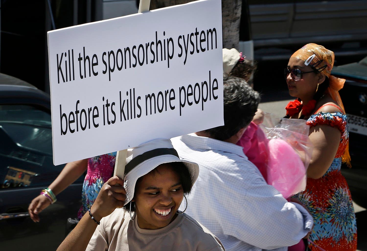 A migrant domestic worker, holds a banner demanding basic labor rights as Lebanese workers, during a march at Beirut's seaside, Lebanon. (File photo: The Associated Press)