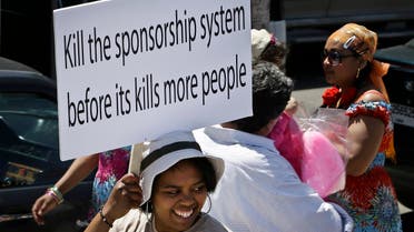 A migrant domestic worker, holds a banner demanding basic labor rights as Lebanese workers, during a march at Beirut's seaside, Lebanon, Sunday, April 28, 2013. (AP)