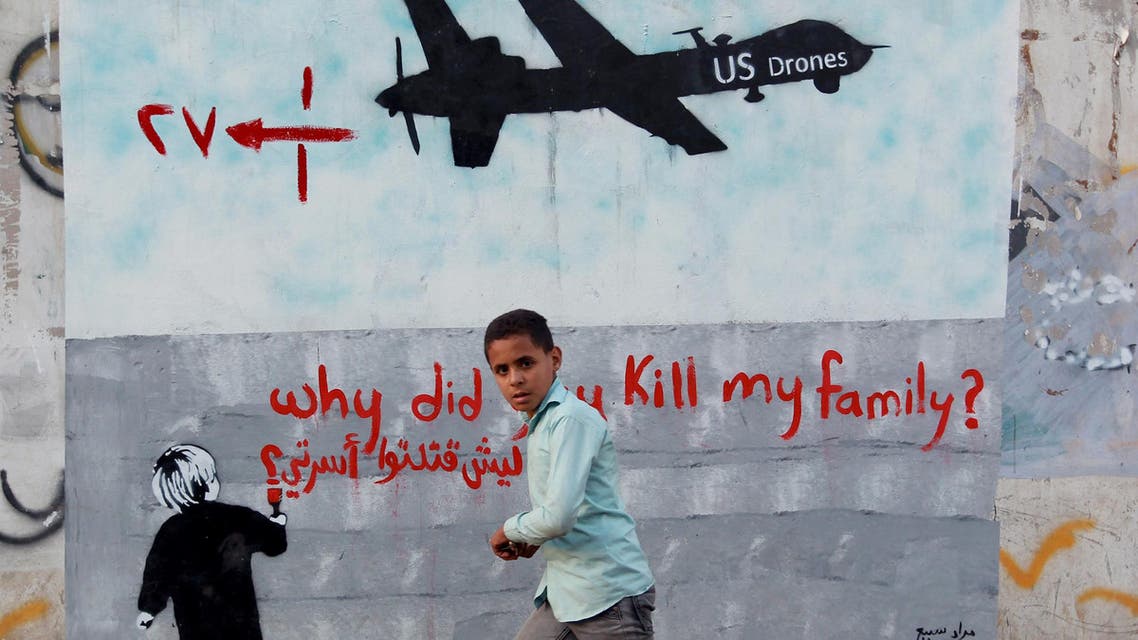 A Yemeni boy (C) walks past a mural depicting a US drone and reading " Why did you kill my family" on December 13, 2013 in the capital Sanaa. (AFP)