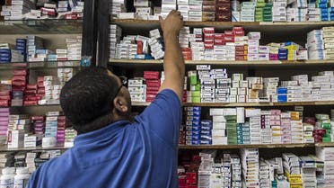 An Egyptian pharmacy employee reaches out to grab a box of medicine in a pharmacy in the capital Cairo. (AFP)