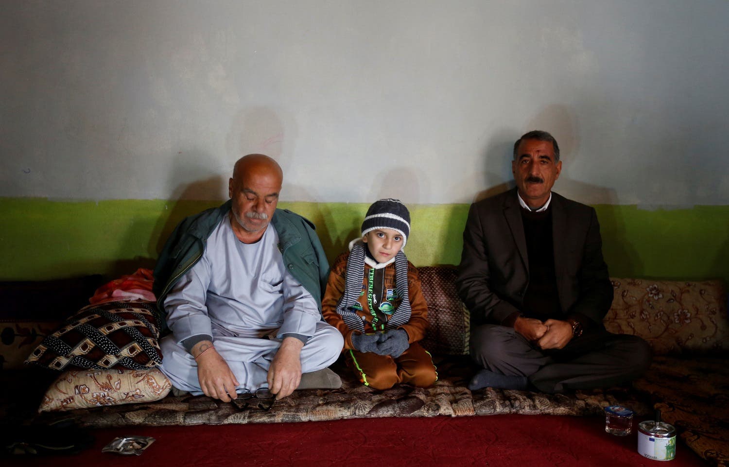 Ayman sits beside his uncle Samir Rasho Khalaf (L) after he was returned to his Yazidi family in Duhok, Iraq. (Reuters)