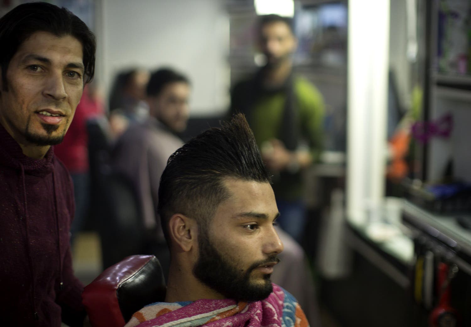 A client sits in a hair salon after barber Ramadan Edwan performed a technique that utilises fire to straighten his hair, in the Rafah refugee camp, in the southern Gaza Strip on February 1, 2017. AFP
