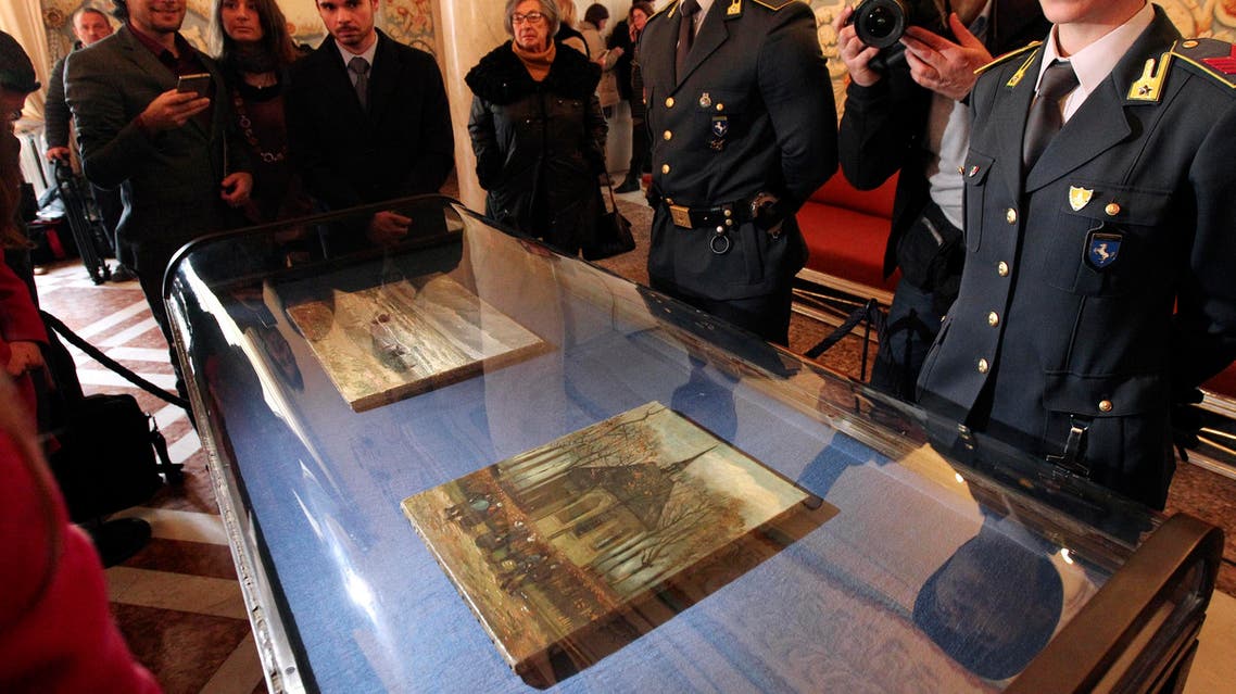 Two Italian policemen of the Guardia di Finanza (Financial Police) stand guard by the two recently recovered stolen paintings by late Dutch artist Vincent Van Gogh entitled "Congregation Leaving the Reformed Church in Nuenen" (L) and "The Beach At Scheveningen During A Storm" (R) displayed at the Capodimonte Museum in Naples on February 6, 2017. (AFP)