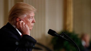 President Donald Trump looks adjusts his earpiece during a joint new conference with Japanese Prime Minister Shinzo Abe in the East Room of the White House, in Washington, Friday, Feb. 10, 2017. (AP Photo/Carolyn Kaster)