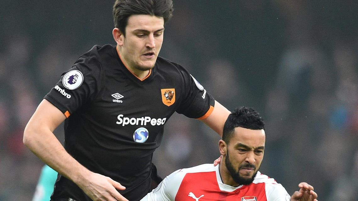Harry Maguire and Theo Walcott. AFP